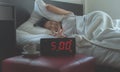 Young asian woman hates getting stressed waking up early 5 o`clock,Alarm clock