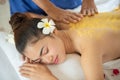 Beautiful Asian woman having exfoliation treatment with body scrub in spa salon, scrubbing and skin care concept, enjoying and Royalty Free Stock Photo