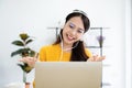 Young asian woman in headphone having conversation chatting while using laptop at house Royalty Free Stock Photo