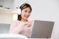 Young asian woman with headphones while make video conference by laptop computer Royalty Free Stock Photo