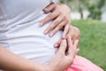 Young asian woman and her husband together caressing her pregnant belly. Pregnancy, love concept. Mom and dad waiting for newborn