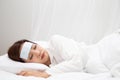 Young Asian woman with high fever while sleeping on white bed at home. Royalty Free Stock Photo