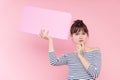 Young Asian woman holding a blank banner plate in her hands with place for text. Fake news concept.