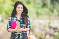 Young asian woman holding books while walking on the park Royalty Free Stock Photo