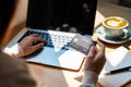 Young woman holding a credit card and using computer for making online payment shopping at coffee shop Royalty Free Stock Photo