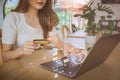 Young Asian woman holding credit card and using laptop computer. Beautiful happy young girl in cafe. Online shopping, E-commerce, Royalty Free Stock Photo