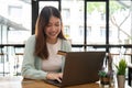 Young asian woman holding credit card and using laptop computer. Online shopping concept Royalty Free Stock Photo