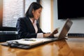 Young asian woman holding credit card and using laptop computer for purchase product on internet in home office. Online shopping Royalty Free Stock Photo