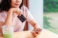 Young woman holding a credit card and using smart phone for make an online shopping payment at home Royalty Free Stock Photo