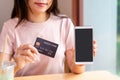 Young woman holding a credit card and using smart phone for make an online shopping payment at home Royalty Free Stock Photo