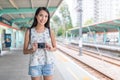 Young asian Woman holding digital camera in light rail station Royalty Free Stock Photo