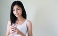 Young Asian woman holding glass of water in her hand on white background. Healthy concept Royalty Free Stock Photo