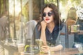 Young asian woman holding her smartphone in a coffee shop Royalty Free Stock Photo