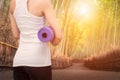 Young asian woman holding her yoga mat in nature bamboo forest. Royalty Free Stock Photo