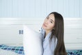Asian woman holding pillow and smiles on the bed in her bedroom. Royalty Free Stock Photo