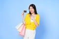 Young asian woman holding shopping bags and showing credit card isolated on color background Royalty Free Stock Photo
