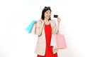 Young asian woman holding shopping bags and showing credit card isolated on white background Royalty Free Stock Photo