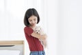 A young Asian woman holding a white Maltese puppy in her bedroom. Girl and puppy dog Royalty Free Stock Photo