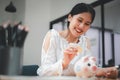Young Asian woman inserts coins into a piggy bank, saving money for his future plans. Royalty Free Stock Photo