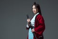 young asian woman in kimono holding katana and looking away Royalty Free Stock Photo