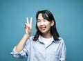 Young asian woman laugh and showing peace or victory sign at camera. Emotion and feelings. Royalty Free Stock Photo