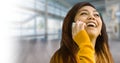 Young asian woman laughing while talking on smart phone Royalty Free Stock Photo