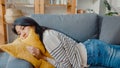 Young asian woman lay down on comfortable sofa in living room sleep after hard time work day and feel sick and bad, tired female Royalty Free Stock Photo