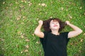 Young Asian woman laying on the green grass listening to music in the park with a chill emotion. Royalty Free Stock Photo