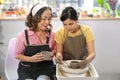 Young asian woman learning how to make handicraft crockery in pottery workshop. Leisure activity, handicraft, hobbies