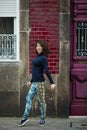 Young asian woman in leggings and sneakers warm-up near the wall on street, Porto