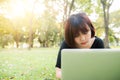 Young asian woman legs on the green grass with open laptop. Girl hands on keyboard. Distance learning concept. Royalty Free Stock Photo