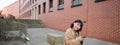 Young asian woman listens music in wireless earphones, uses smartphone on street, walks around city on sunny day Royalty Free Stock Photo