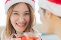 Young asian woman with long brown hair wearing red and white santa hat and pink sleeveless dress celebrating and cheering with her Royalty Free Stock Photo