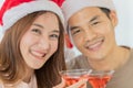 Young asian woman with long brown hair wearing red and white santa hat and pink sleeveless dress celebrating and cheering with her Royalty Free Stock Photo