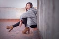 Young Asian woman is looking into the camera while leaning against a wall Royalty Free Stock Photo