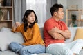 Young asian woman looking at her angry husband, home interior Royalty Free Stock Photo