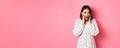 Young asian woman looking intrigued, gossiping and saying wow with curious face, looking interested at camera, standing