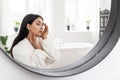 Young asian woman looking at mirror, checking skin Royalty Free Stock Photo