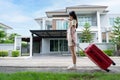 A young Asian woman with luggage standing in front of a new buying home to move into a new house. Start life at own or rented flat