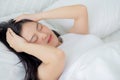 Young asian woman lying on bed pain headache in the bedroom at home, unhappy female exhaustion and sick headache. Royalty Free Stock Photo