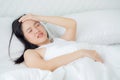 Young asian woman lying on bed pain headache in the bedroom at home. Royalty Free Stock Photo