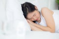 Young asian woman lying on bed pain headache in the bedroom at home, unhappy female exhaustion and sick headache. Royalty Free Stock Photo