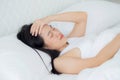 Young asian woman lying on bed pain headache in the bedroom at home, unhappy female exhaustion and sick headache. Royalty Free Stock Photo