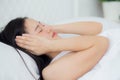 Young asian woman lying on bed pain headache in the bedroom at home, unhappy female exhaustion and sick headache. Royalty Free Stock Photo