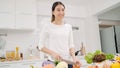 Young Asian woman making salad healthy food in the kitchen, beautiful female in casual use organic vegetables lots of nutrition Royalty Free Stock Photo