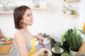 Young asian woman making salad in kitchen smiling and laughing h Royalty Free Stock Photo