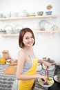 Young asian woman making salad in kitchen smiling and laughing happy at home Royalty Free Stock Photo