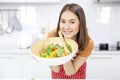 A young Asian woman making salad in a modern kitchen Royalty Free Stock Photo