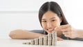 Young Asian woman making stack of coins. invest save finance concept.