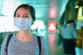 Young Asian woman with mask for protection from corona virus outbreak at the footbridge with blue light